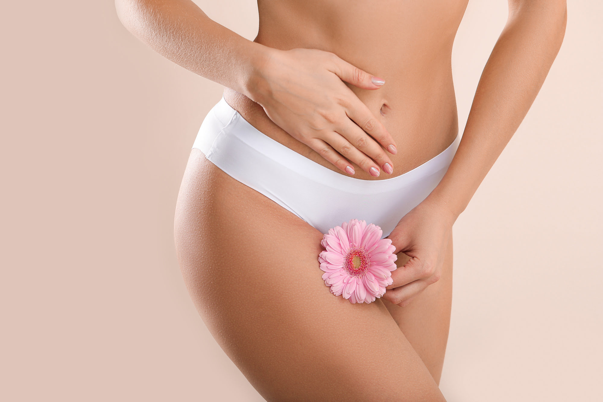 Young woman with flower on light background. Gynecology concept | Coral Springs Med Spa in Coral Springs, FL